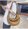 Individual checking phone while carrying a stylish brown travel bag