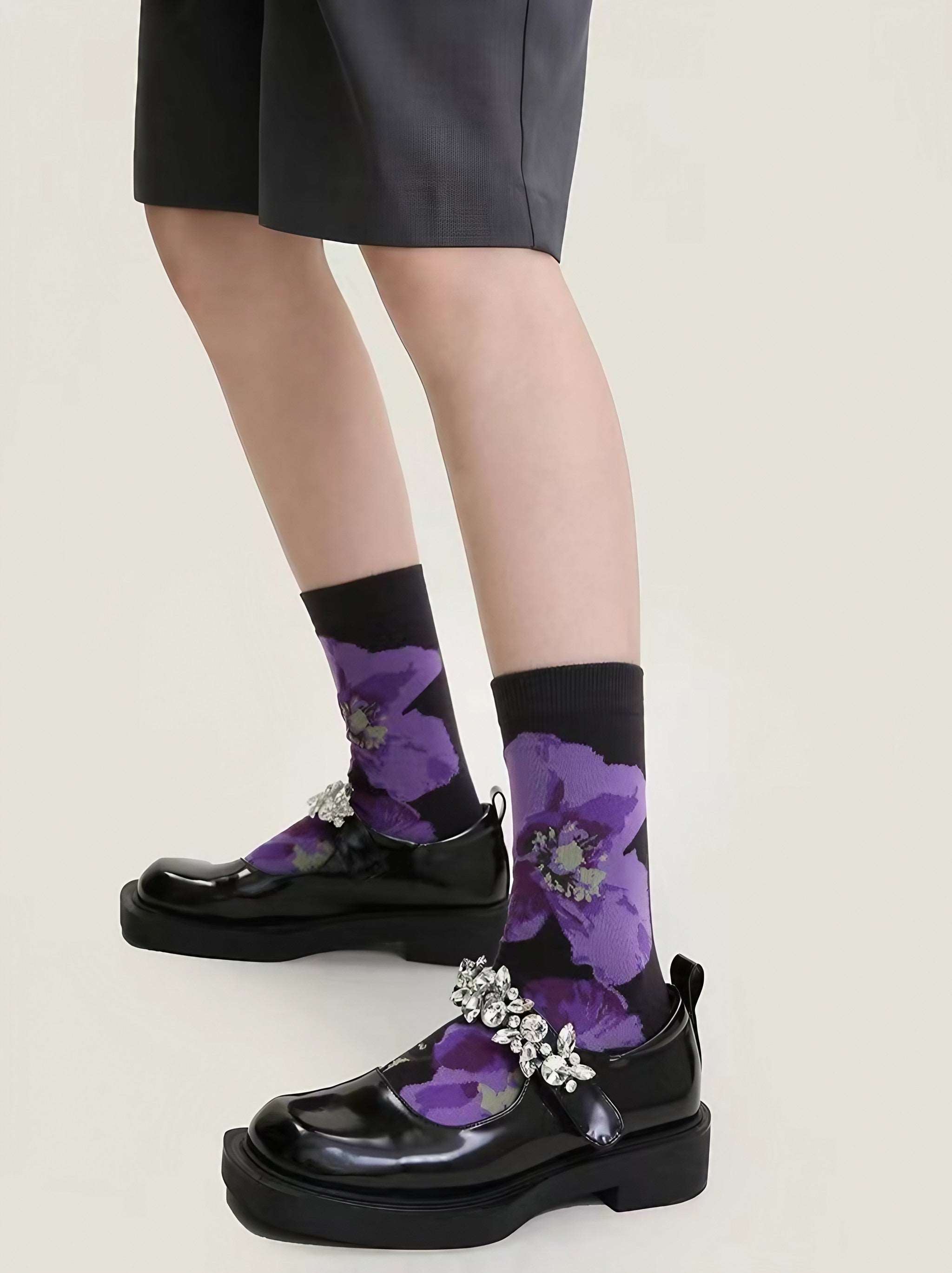 Female feet clad in purple socks with contrasting black floral accents