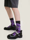 Female feet clad in purple socks with contrasting black floral accents