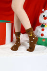 Female feet in festive holiday socks alongside a cute snowman decoration