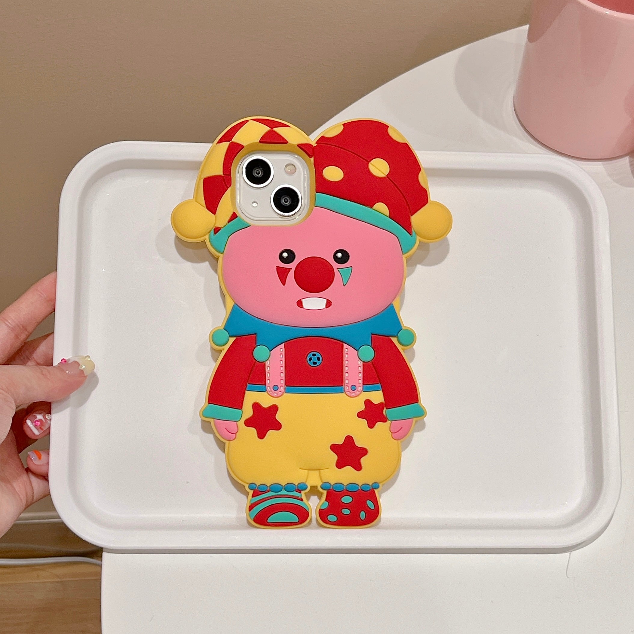 A person holding a Loopy Pierrot iPhone case with a Pororo-inspired cartoon character for iPhone 15 Pro Max