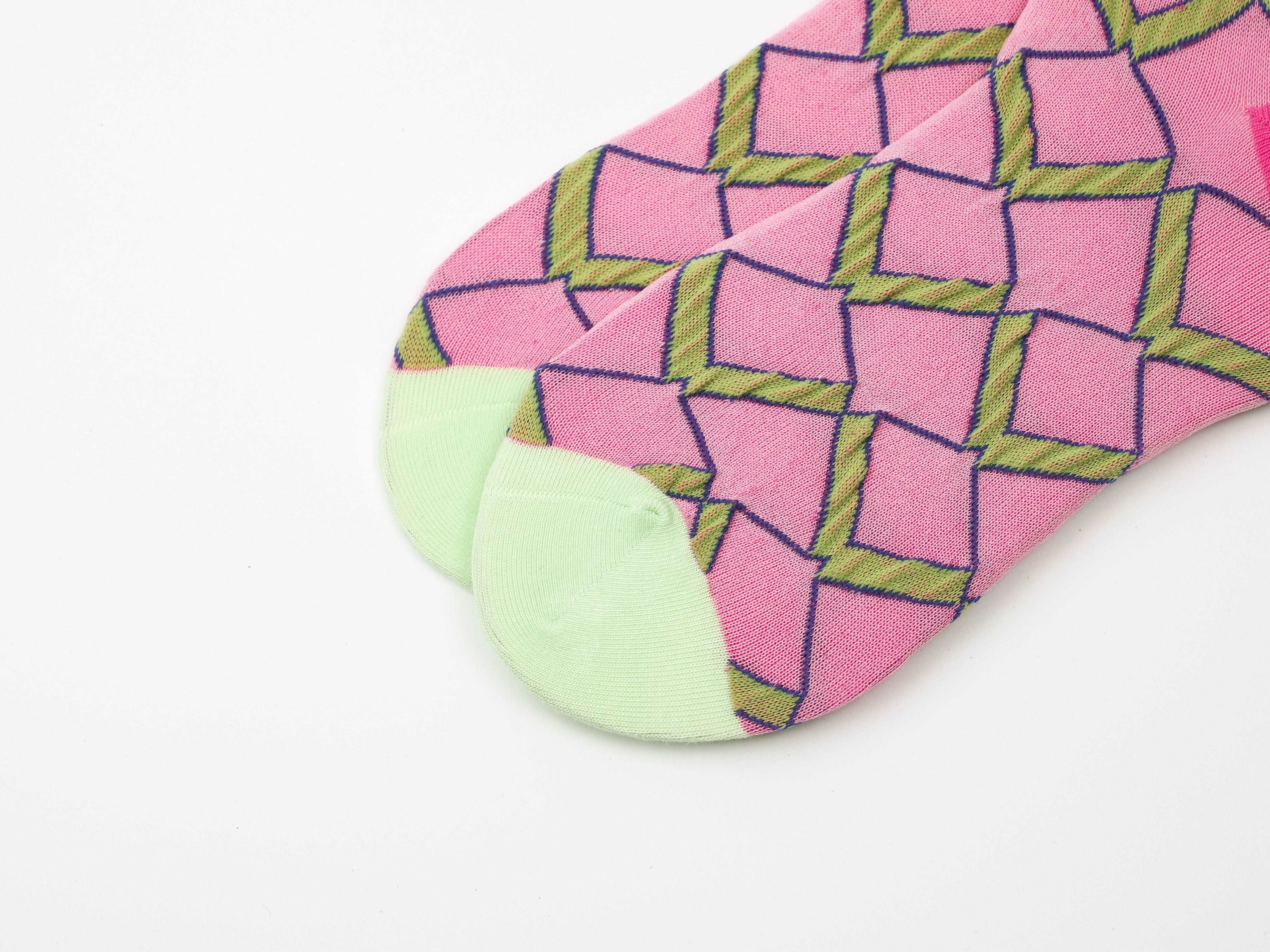 A vibrant pink sock with green geometric detailing from the 1+2 Socks Set