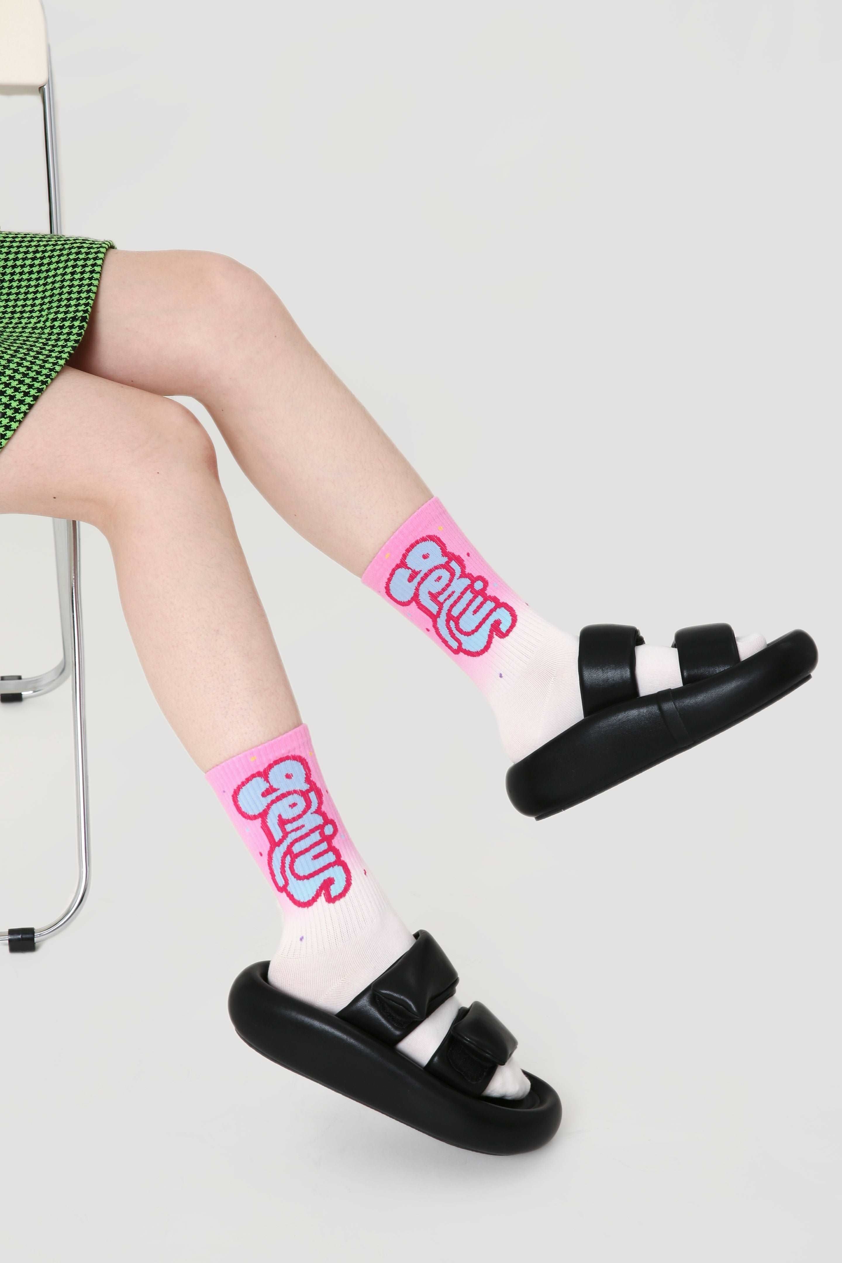 Female feet adorned with pink socks from the set, paired with black sandals