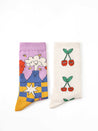 Two pairs of socks from the set, one with a cherry pattern and the other with star motifs