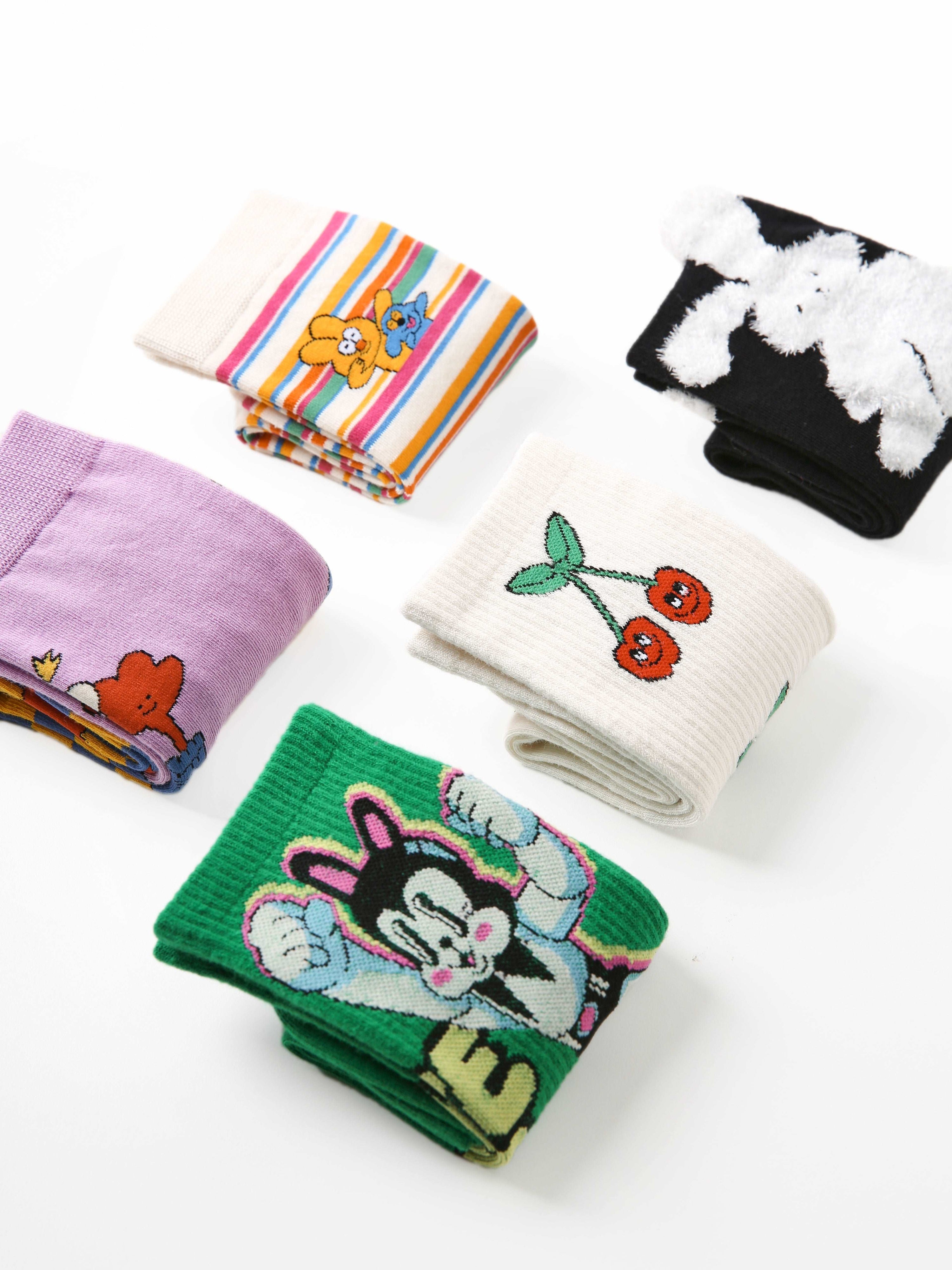 An assortment of five pairs of socks from the set, each with unique cartoon illustrations