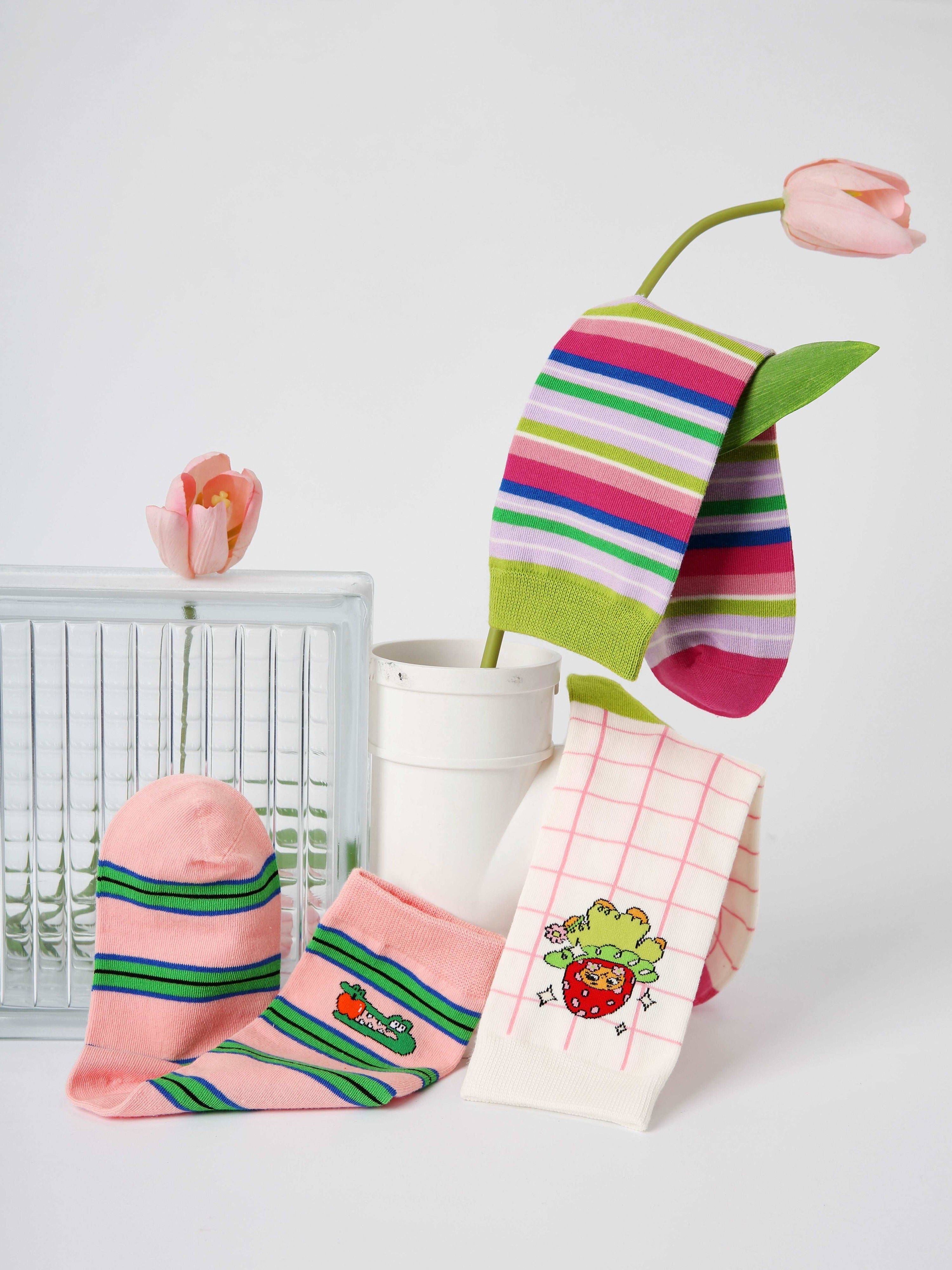 An arrangement of Y2K-inspired socks with autumn and winter themes, alongside a decorative flower