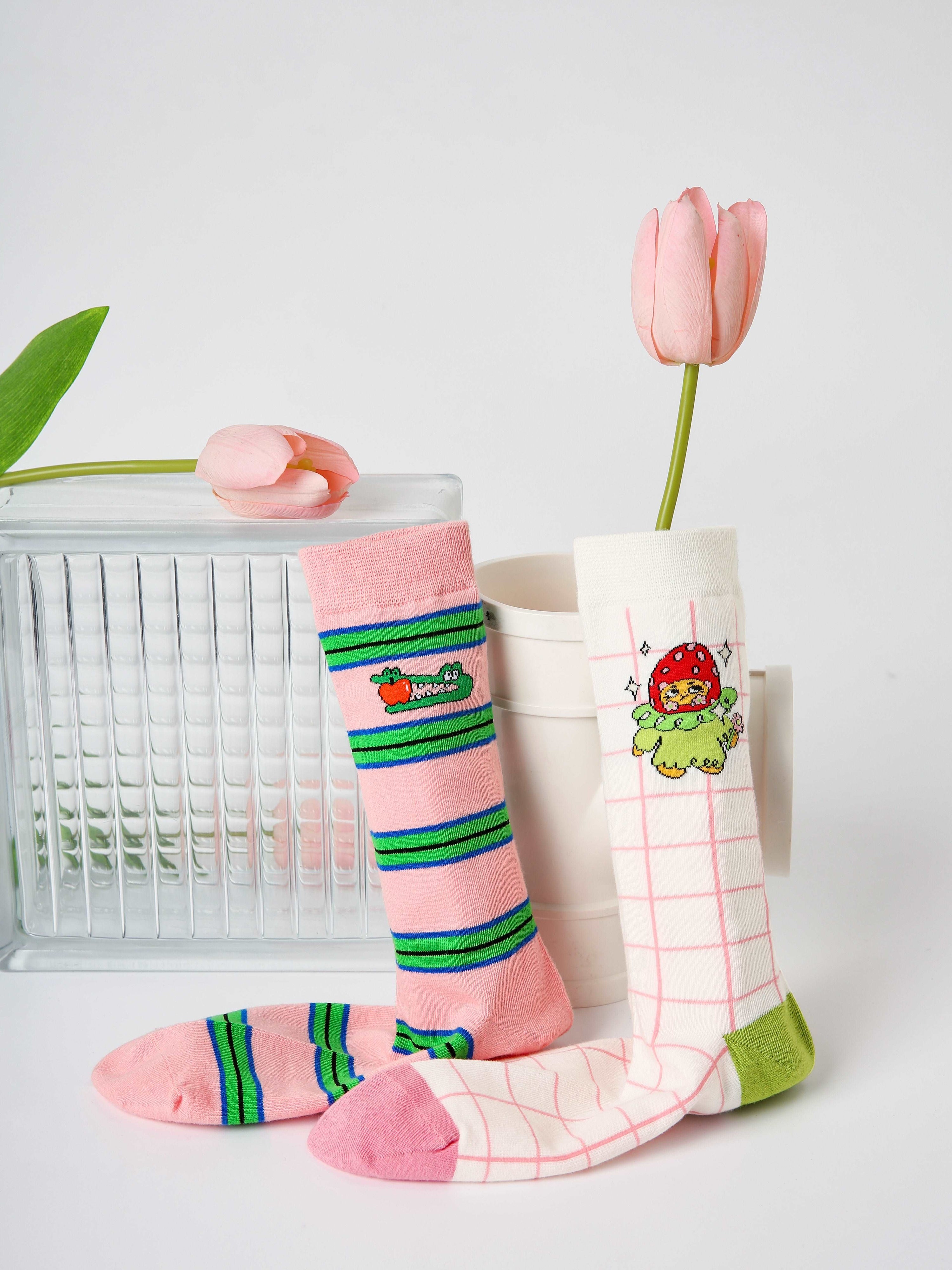 A duo of socks, one with pink and the other with green stripes