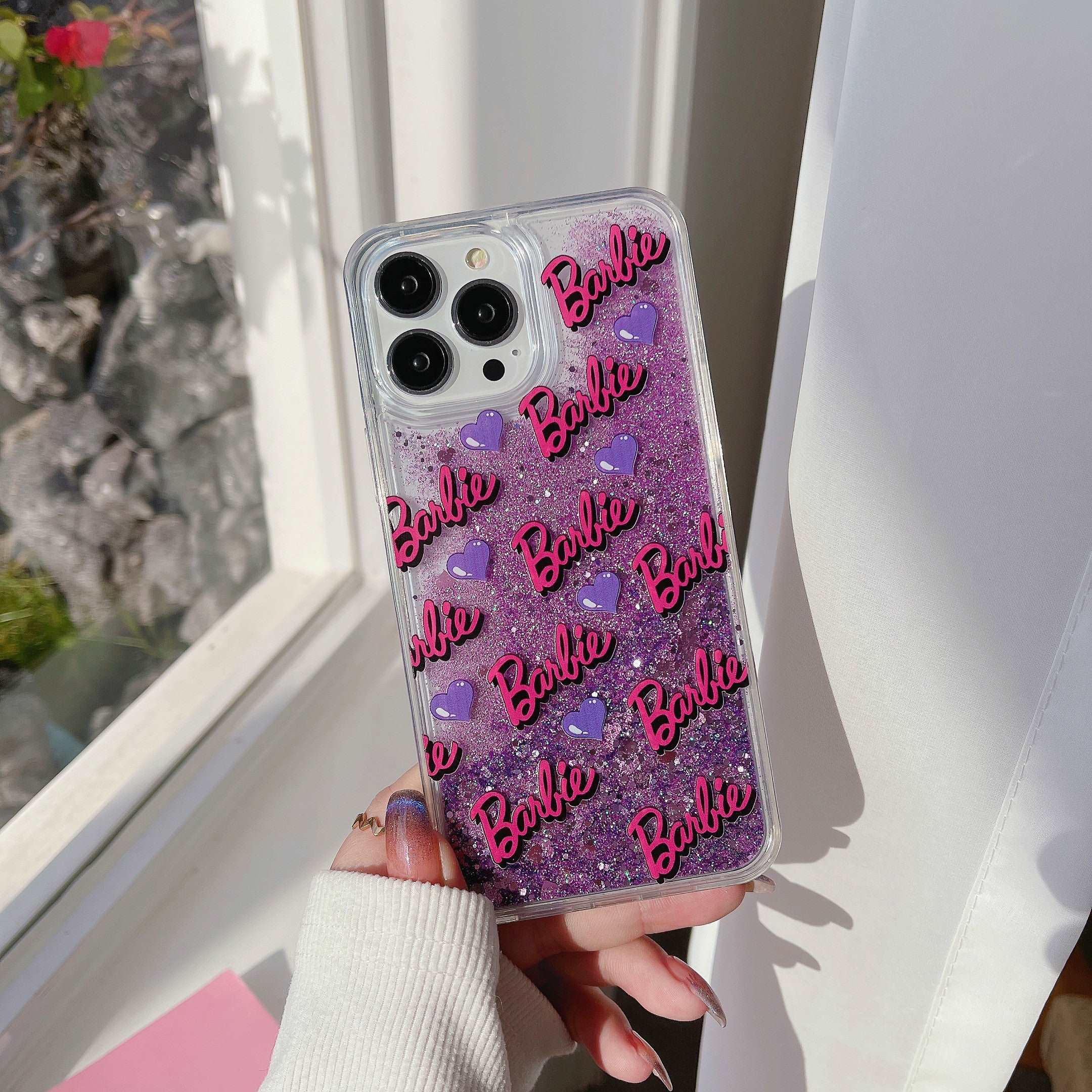 Individual showcasing a shimmering purple Barbie case for iPhone