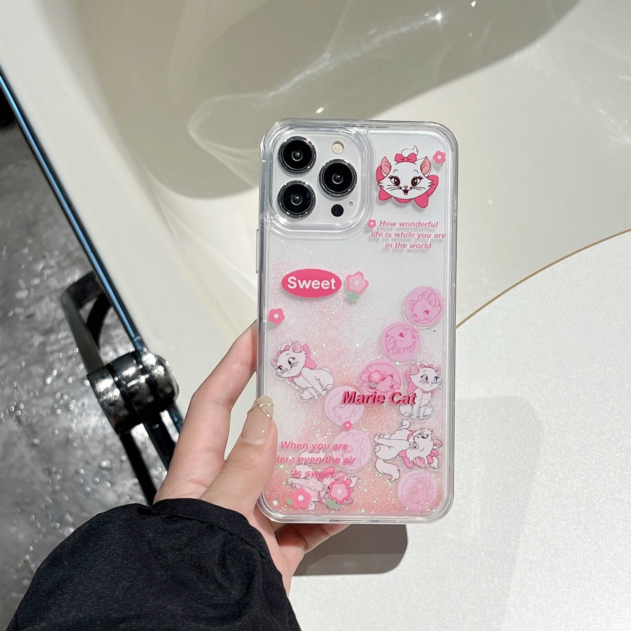 Hand presenting a shockproof iPhone case with pink accents and Marie the Cat motif